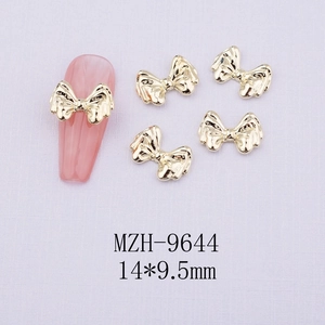 Macro shot of 14x9.5mm gold metal bow nail charms showing details and MZH-9644 size