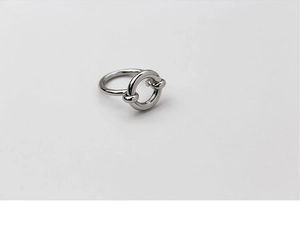 Macro shot of silver knot ring with polished round finish and minimalist metallic texture
