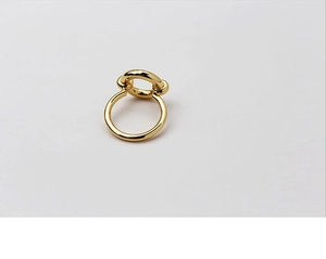 Detail of interlocking gold-plated rings showing a minimalist geometric texture and polished finish