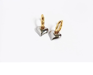 Detail shot of two-tone heart dangle earrings with gold hoop and silver 3D heart charm