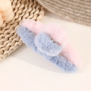 Detailed close-up of a pink and blue plush shark hair claw clip on a woven background