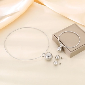 Detailed view of silver stainless steel jewelry set with hollow sphere charms on silk