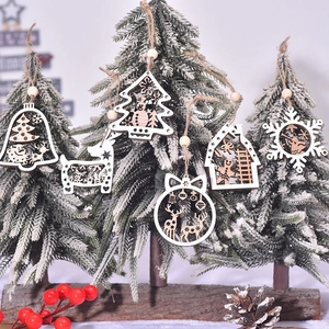 Wooden cutout Christmas ornaments featuring deer and trees on a snowy pine branch