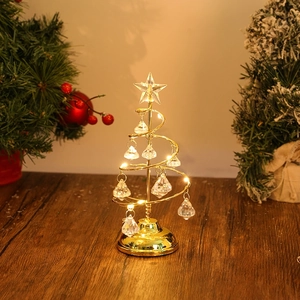 Golden spiral Christmas tree lamp with crystal pendants and star top on wooden surface