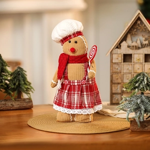 Detailed plush gingerbread man doll with red plaid dress and chef hat in festive setting