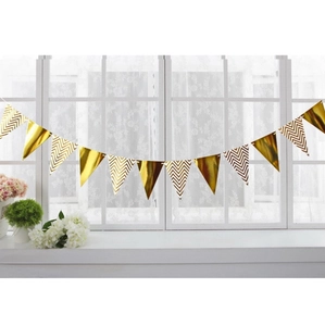 Detail of gold triangle pennant banner hanging by a window for birthday party decoration