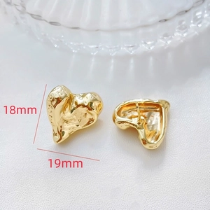 Detailed macro view showing 19x18mm irregular heart earrings with hammered gold texture