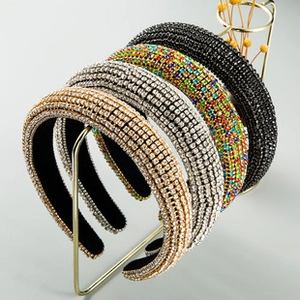 Detail view of five luxury crystal-encrusted knotted headbands on a display stand