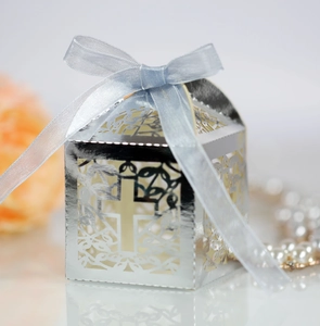 Detail of silver laser-cut cross gift box with a light blue satin ribbon bow