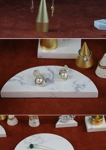 Detail of elegant gold jewelry set with pearls and emerald pendant on red velvet