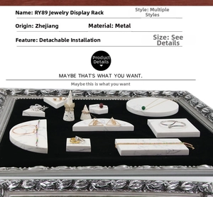 Detailed table showing metal jewelry display set with marble textured geometric blocks