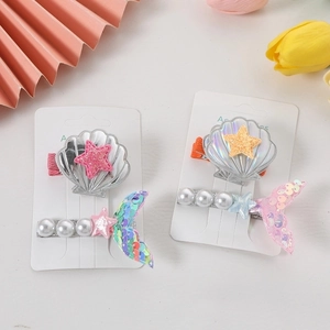 Pastel mermaid hair clips with sea shells and pearls on a retail card for girls