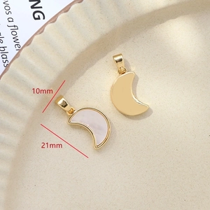 Detailed size view of moon-shaped gold plated pendants with white mother of pearl inlay