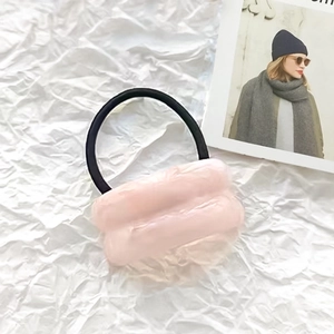 Pink fluffy faux fur elastic hair tie with marble texture detail on a minimalist background