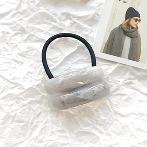 Detail of a black elastic hair tie with transparent bubble accents on white paper