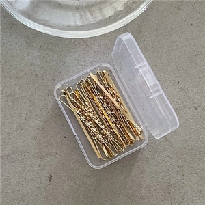 Golden metal hair clips set in transparent storage box for daily styling and makeup