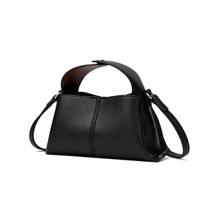 Close-up of black litchi pattern leather handbag with golden hardware and shoulder strap