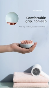 Detail of ergonomic scalp massage brush with anti-slip texture and comfortable blue handle