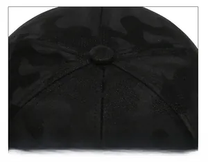 Close-up of black baseball cap top showing camo texture and detailed stitching