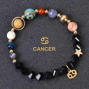 Detail of Cancer zodiac bracelet with faceted obsidian beads and gold-tone planet charms