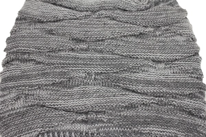Detail of grey knitted hat with diamond pattern weave and warm fleece lining texture