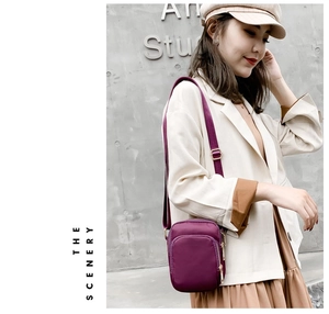 Purple nylon crossbody phone bag shown on a model against a grey industrial wall