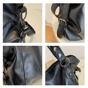 Close-up of black leather tote bag details showing silver metal hooks and stitching