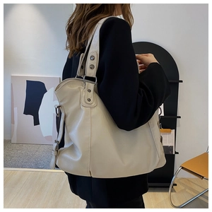 Side view of large beige PU leather tote bag on model showing spacious capacity