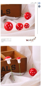 Detail of mini red foam mushrooms with white spots and green wire stems for micro landscapes