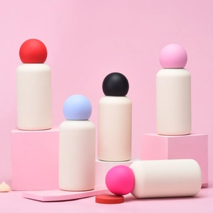 Creative 350ml matte water bottles with colorful spherical lids on geometric props
