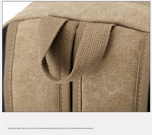Macro detail of khaki canvas backpack showing sturdy stitching and top handle texture