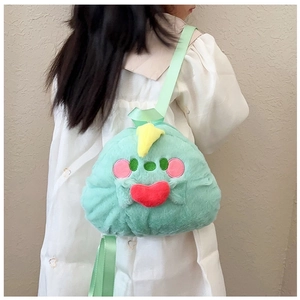 Detail of cute green plush monster backpack showing soft texture and pink blush accents