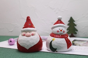 Detailed view of hand-carved wooden Santa Claus and snowman figurines on festive table