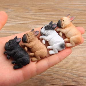 Miniature resin French Bulldog figurines in four colors held in hand for scale