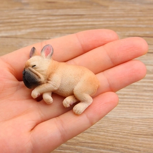 Close-up of mini resin French Bulldog puppy figurine in hand for scale and detail