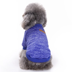 Detail of blue knitted dog sweater featuring a classic brown leather label and ribbed cuffs