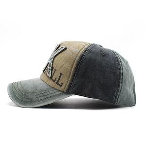 Detail view of vintage baseball cap featuring distressed stitching and X embroidery