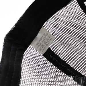 Close-up of the wash care label showing 65% cotton and 35% polyester on a black mesh cap