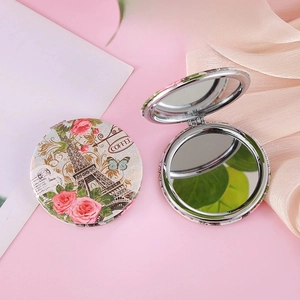 Detailed view of a vintage Eiffel Tower foldable pocket mirror with rose floral pattern