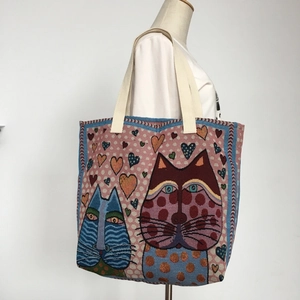 Woven tapestry tote bag with cartoon cat patterns and colorful hearts on a white background