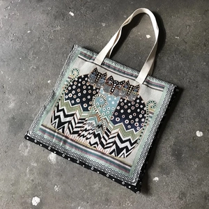 Flat lay of canvas tote bag with abstract cat patterns on concrete background