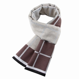 Macro detail of the brown and beige checkered scarf with soft wool texture and black fringe