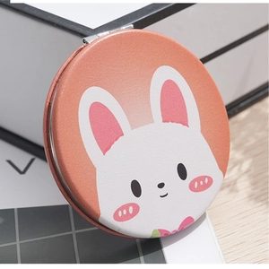 Close-up of a mini round folding mirror featuring a cute orange cartoon rabbit PU leather cover