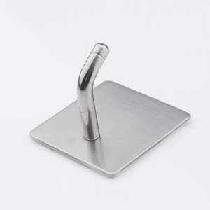 Macro detail of silver brushed stainless steel wall hook with square base and curved arm