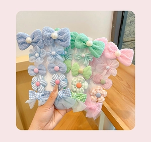 Detailed view of colorful fabric bow and flower hair clips set for young girls