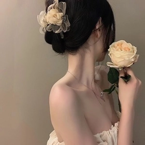 Elegant beige flower hair clip worn by model for a sophisticated and feminine look