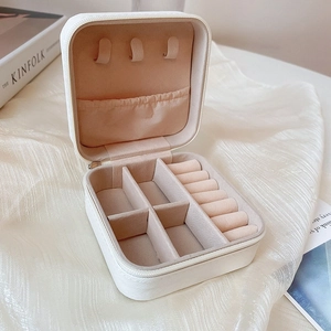 Detailed layout of portable jewelry box with necklace hooks and ring slots in beige