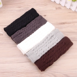 Detail of cable knit winter warmers in black, grey, white and brown soft yarn texture