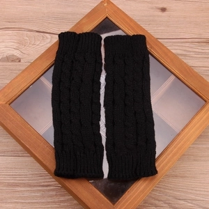 Close-up of black cable-knit wool winter warm gloves with thick texture and elastic weave