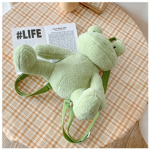 Detailed view of the soft plush texture and green adjustable straps of the frog backpack